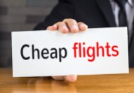 Cheap flights, message on white card and hold by businessman