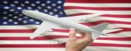Airplane in hand with flag on background - United States
